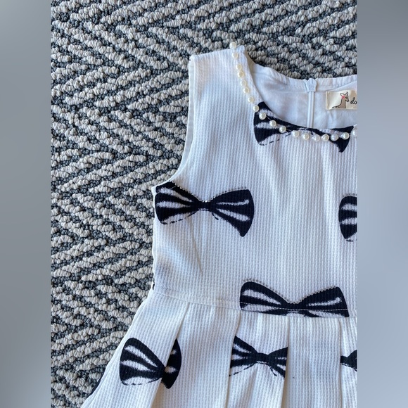 Little girls dress with a pearl lined neck line and a bow print - Picture 2 of 2